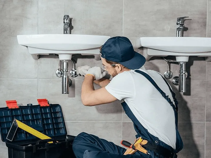 Professional Plumber working on clean modern pipes